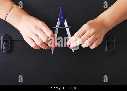 Hände halten einen technischen Kompass auf einer alten und verfallenen schwarz Aktenkoffer Stockfoto
