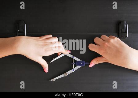 Hände halten einen technischen Kompass auf einer alten und verfallenen schwarz Aktenkoffer Stockfoto