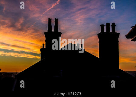 Wimbledon London, UK. 3. Oktober 2016. Wohn Dächern Silhouette gegen einen bunten Herbst Sonnenaufgang mit schönen Feuer Himmel in Wimbledon SW London Stockfoto