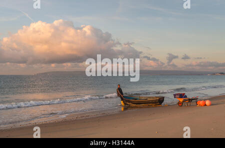 Ein Fischer startet ein Ruderboot aus Bournemouth Beach, zum Fischfang in Poole Bay, Dorset, Großbritannien Stockfoto