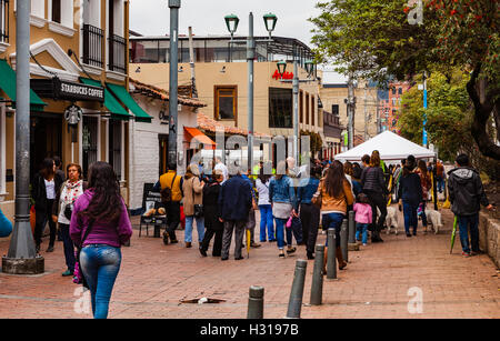 Bogota, Kolumbien - 2. Oktober 2016: Wähler ausgehend über Plaza Usaquen, in den Anden Hauptstadt Stadt Bogota, in dem südamerikanischen Land Kolumbien, auf der historischen Volksabstimmung über den Friedensprozess mit der FARC abstimmen. Vor ihnen sind eine Reihe von Zelten, wo sie an der entsprechenden nummerierten Tabelle abstimmen werden. Auf der linken Seite des Bildes ist das Starbucks-Cafe auf der historischen Plaza Usaquen. Stockfoto