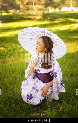 schöne asiatische Frau im Kimono mit Regenschirm Stockfoto