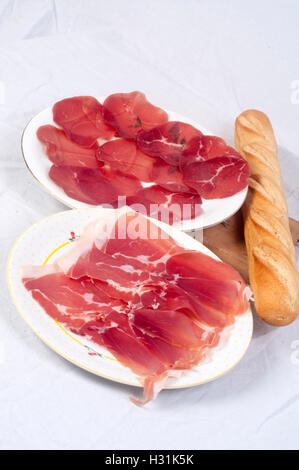 Fleisch-Feinkost mit Bresaola, Crudo di Parma und Baguette-Brot. Stockfoto