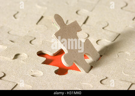 Papier-Rätsel auf einem roten Hintergrund. Ein Puzzle ist geöffnet. Verfügbar in hoher Auflösung und verschiedenen Größen. Stockfoto