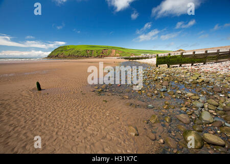 Verlassener Strand mit Sand- und Kiesstrand Abschnitte auf Basis des hohen grasbewachsenen Landzunge unter blauem Himmel am Saint Bienen in Cumbria, England Stockfoto