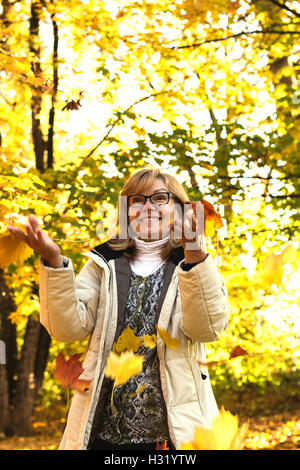 Porträt von Reife attraktive Frau spielt mit Herbst Stockfoto