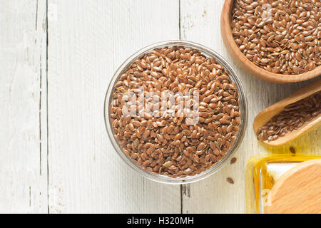 Leinsamen in Schüssel auf Tabellenhintergrund Stockfoto