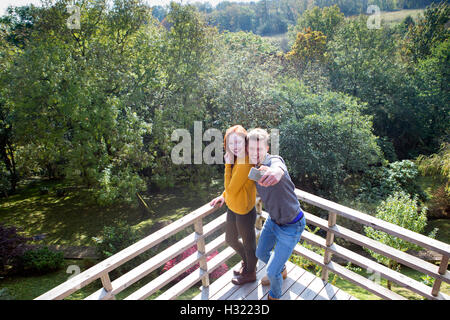 Junges Paar unter einem Selfie auf ihrem Garten Balkon mit einem Smartphone. Stockfoto