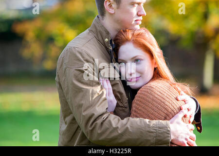 junges Paar kuscheln in einem Park im Herbst zu genießen. Stockfoto