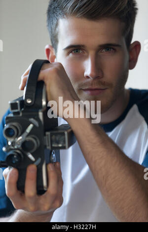 Porträt von einem attraktiven jungen Mann mit einer Videokamera hautnah. Stockfoto