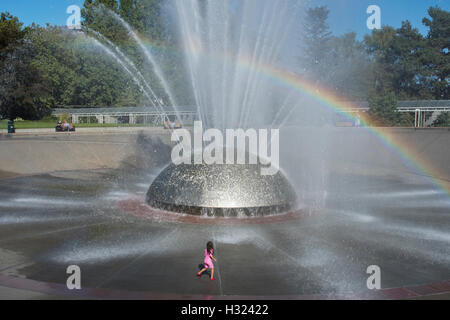Mädchen spielt in der Gischt des International Fountain, Seattle Center, Seattle, Washington, Sommer Stockfoto