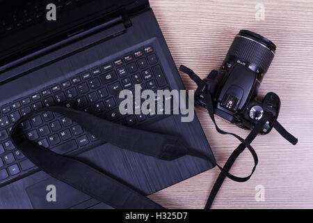 Lay-flat-Image eines Laptop und Kamera auf eine Holzoberfläche Stockfoto