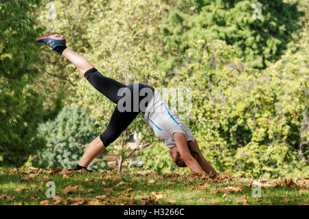 Eine Frau übt Yoga in St. James Park in London, England Vereinigtes Königreich Großbritannien Stockfoto