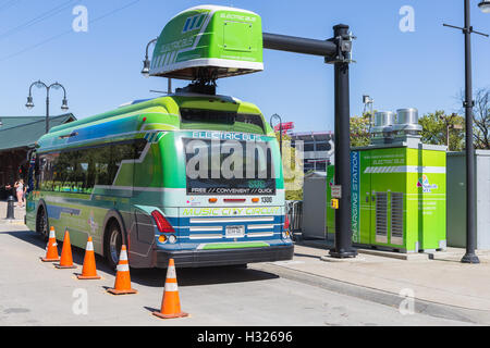 Eine elektrische Musik Stadtkurs Zirkulator Bus Ladungen auf einen israelischen Bus Ladestation am Flussufer Bahnhof in Nashville, Tennessee. Stockfoto