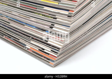 Stapel von alten farbigen Zeitschriften auf weißem Hintergrund Stockfoto