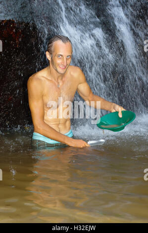 ein Mann-Goldwaschen in einem Fluss mit einer Schleuse box Stockfoto