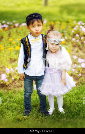 kasachische kleine Jungen und Mädchen gemeinsam spielen im Sommerpark Stockfoto