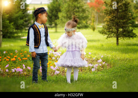 kasachische kleine Jungen und Mädchen gemeinsam spielen im Sommerpark Stockfoto