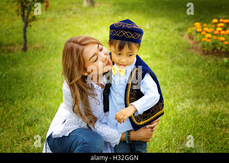 Kasachische Mutter mit Kindern. Sohn und Tochter im Sommerpark Stockfoto