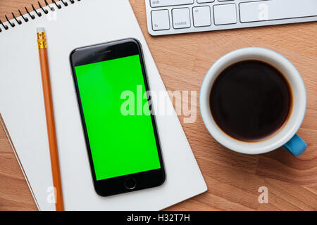 Schwarz Smartphone Tasse Kaffee und Laptop auf dem Schreibtisch aus Holz Stockfoto