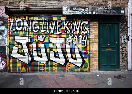 Graffiti, Brixton Künstler und Sänger King Juju auf eine Hortung in Shoreditch, London zu feiern. Stockfoto