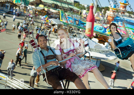 Paare, die Spaß auf Kette Karussell Ketten-Karussell auf dem Oktoberfest Stockfoto