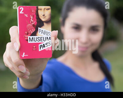 Junge Frau hält Paris Museum Pass 2016 Stockfoto