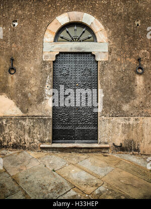 Traditionelle alte Vintage Eisentür und Grunge wall in Toskana, Italien, Europa. Stockfoto