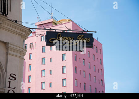 Das Zeichen für Sloppy Joe's Bar in Havana ragen aus der Bar mit einem rosa lackiert Art-Deco-Gebäude im Hintergrund Stockfoto