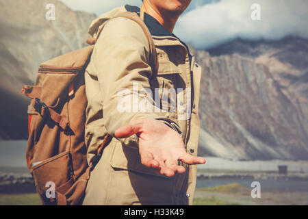 Jung Reisen Mann Kreditvergabe eine helfende hand in einer Outdoor-Berglandschaft. Stockfoto