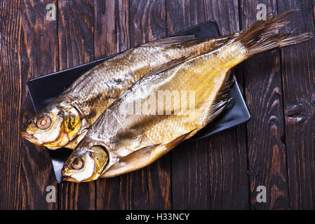 geräucherten Fisch auf Teller und auf einem Tisch Stockfoto