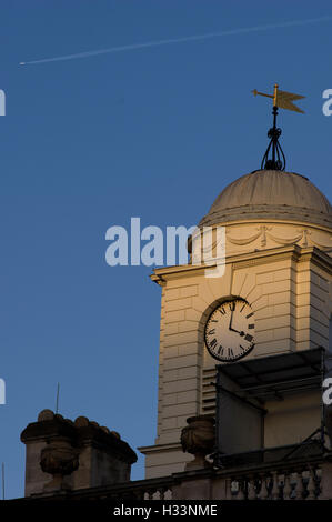 Glockenturm der Kirche im Sonnenuntergang Sonnenlicht mit einer Wetterfahne vor einem tiefblauen Himmel Stockfoto