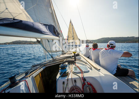 An Bord Ansicht von racing Segelyacht mit Crew auf der Steuerbordseite sitzend Stockfoto