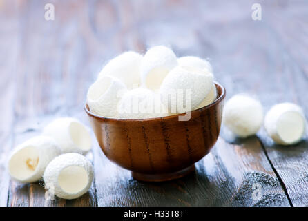 Wattestäbchen in Schüssel geben und auf einem Tisch Stockfoto