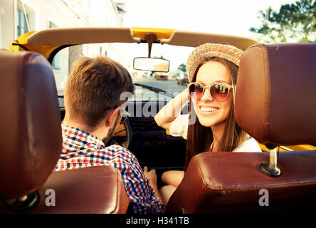 hübsches Paar Blick in die Kamera sitzt im Auto, Blick vom hinteren Sitz Stockfoto