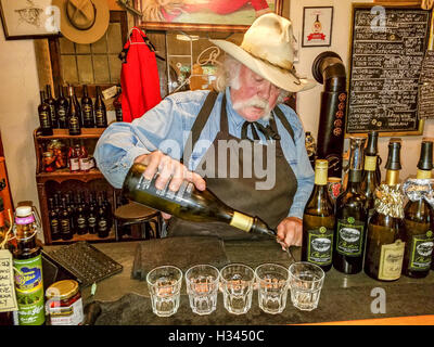 Besitzer Bruce Fuller gießt Wein in Cowboy unter dem Motto Rustico Farm & Cellars Winery in Oliver, südliche Okanagan Valley, BC, Kanada. Stockfoto