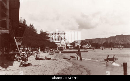 Waikiki-Strand-Szene mit Sonnenanbeter, Surfer und hölzernen Surfboards in Honolulu, Hawaii-Territorium c1920s. Stockfoto