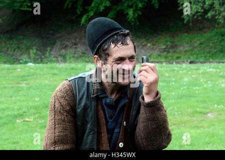 Ein Mann spricht über ein altes Handy mitten in der Natur. Stockfoto