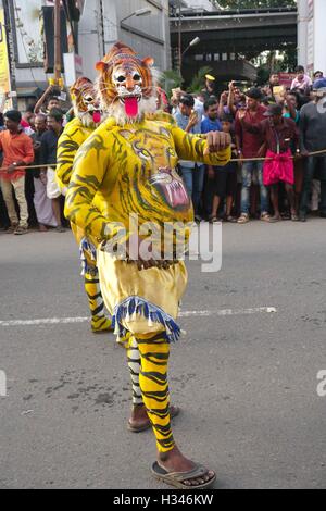 Ausgebildete Tänzer mit ihren sorgfältig lackierten Karosserien Deckmantel der Tiger führen die berühmten Pulikali die Straßen von Thrissur, Kerala Stockfoto