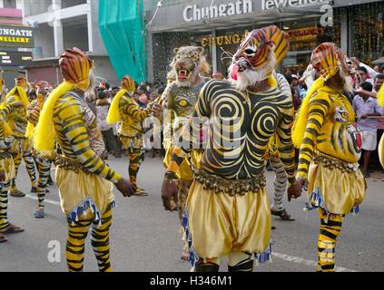 Ausgebildete Tänzer mit ihren sorgfältig lackierten Karosserien Deckmantel der Tiger führen die berühmten Pulikali die Straßen von Thrissur, Kerala Stockfoto