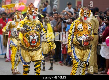 Ausgebildete Tänzer mit ihren sorgfältig lackierten Karosserien Deckmantel der Tiger führen die berühmten Pulikali die Straßen von Thrissur, Kerala Stockfoto