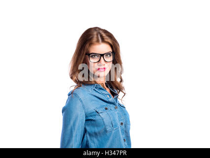 Frau in Denim-Bluse und schwarze Brillen, Studio gedreht. Stockfoto