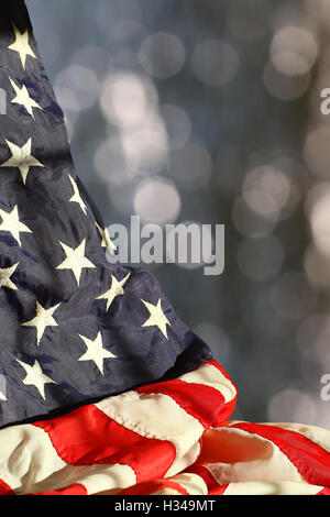 Wellige amerikanische Flagge vor verschwommenen glitzernden Hintergrund mit Platz für Kopie Stockfoto