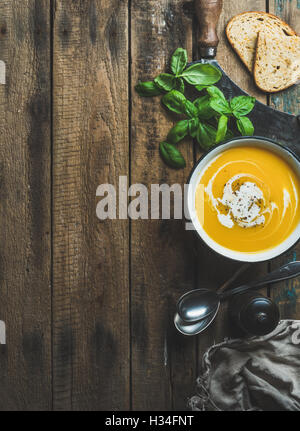 Kürbis Cremesuppe in Schüssel mit frischem Basilikum und Gewürzen Stockfoto
