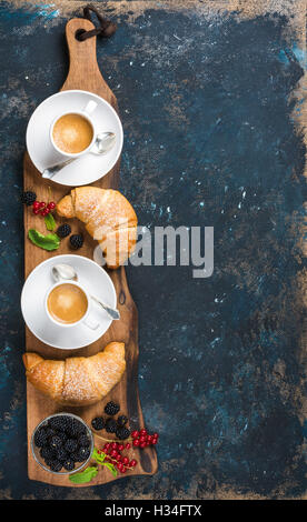 Frisch gebackene Croissants mit Garten Beeren und Kaffeetassen Stockfoto