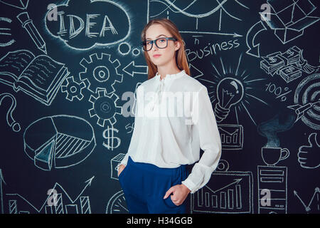 Porträt von eine Geschäftsfrau in Gläsern auf dunklem Hintergrund mit Bildern Stockfoto