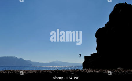 Santorini springen Silhouette ein Meer Stockfoto