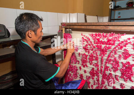 Indonesien, Bali, Singaraja, Pertenunan Berdikari weben Workshop, Arbeiter Hand binden Farbstoff widerstehen Fäden Stockfoto