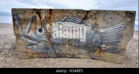 Ein Weltkrieg 2 Pillbox auf Cayton Bay Beach mit Graffiti bemalt Fisch essen einen Mann, North Yorkshire England UK Stockfoto