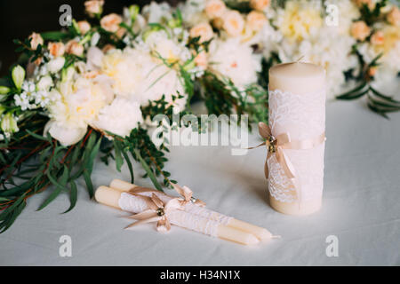 Hochzeit Kerzen sind am Tisch in der Nähe von schönen Blumen Rosen. Tischdekoration für die Hochzeitsfeier. Stockfoto